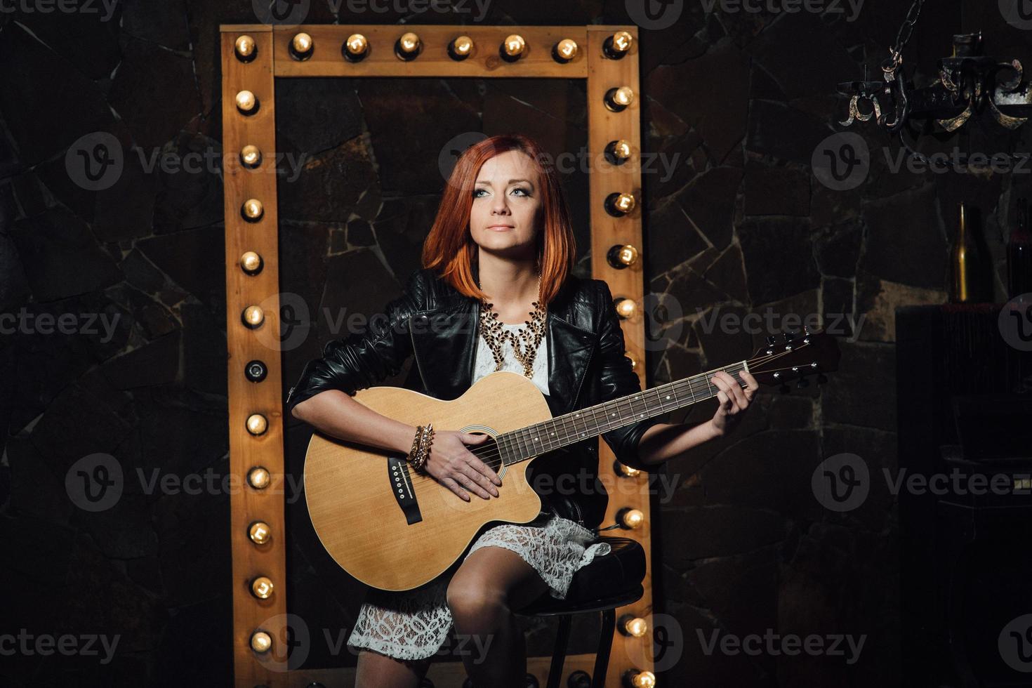 young girl with red hair with an acoustic guitar photo