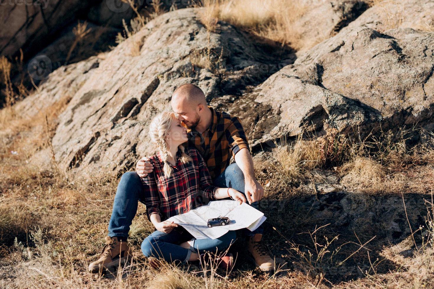 Bald guy with a beard and a blonde girl are looking at the map and looking for photo