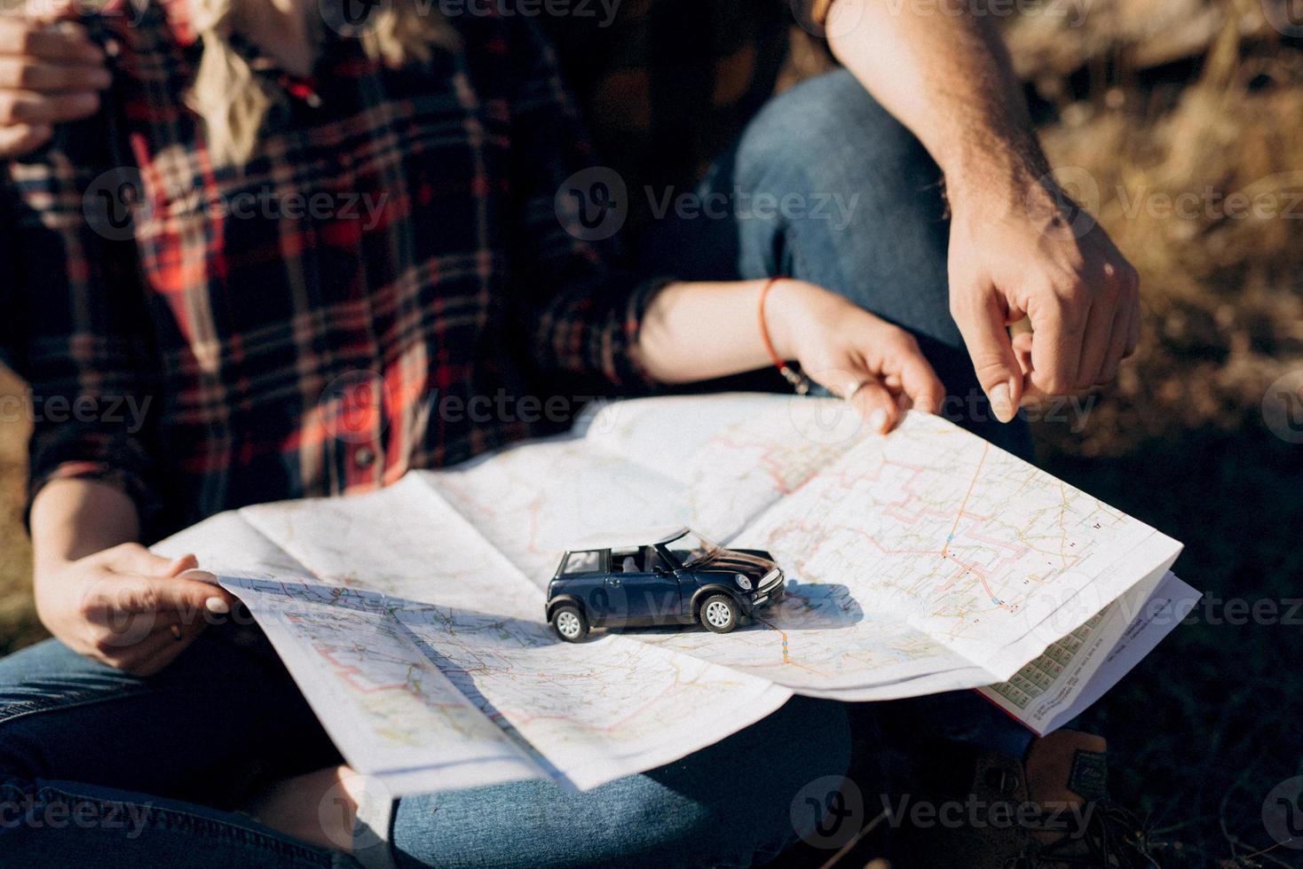 chico calvo con barba y una chica rubia están mirando el mapa y buscando foto