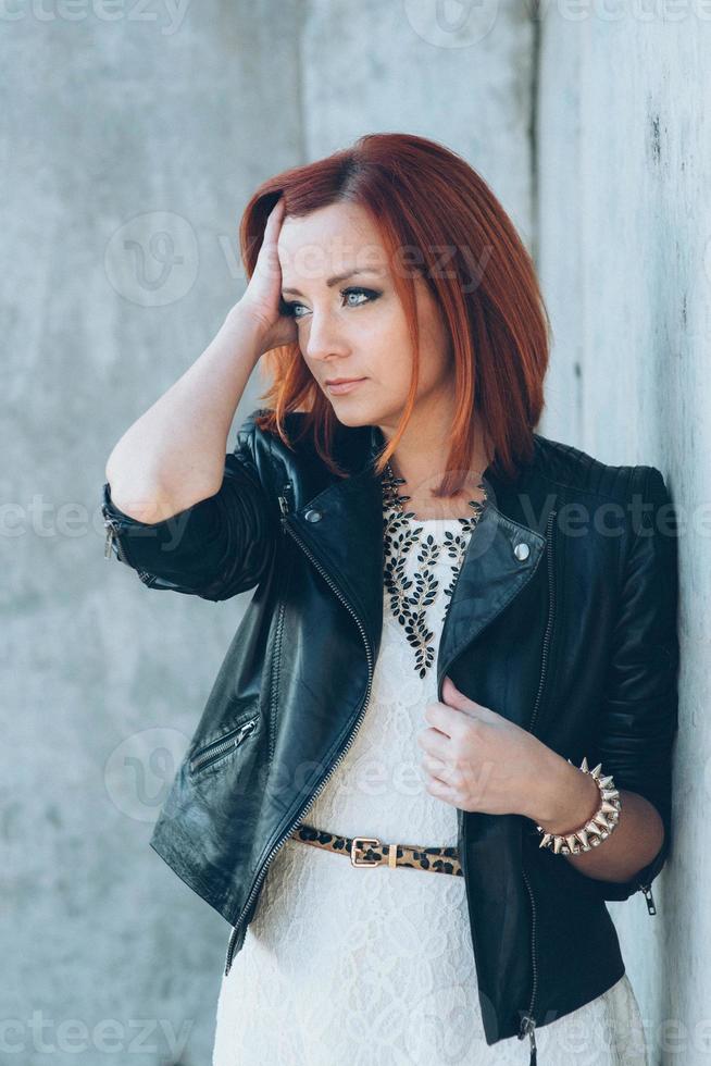 chica pelirroja con una chaqueta negra y gafas azules foto