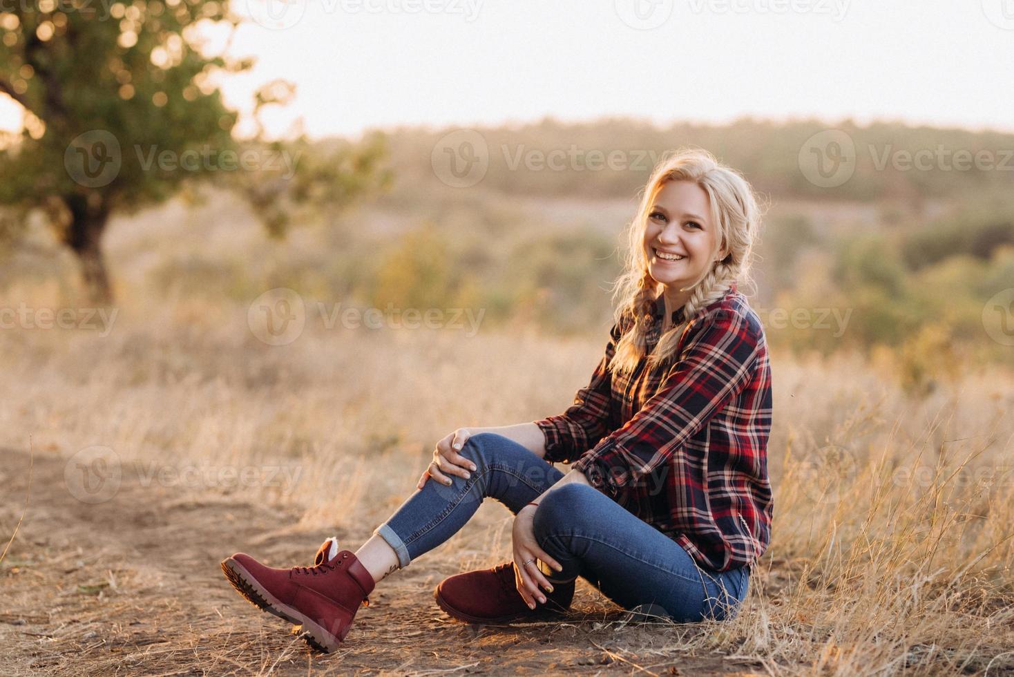 blonde with pigtails in a shirt jeans red shoes smiling photo