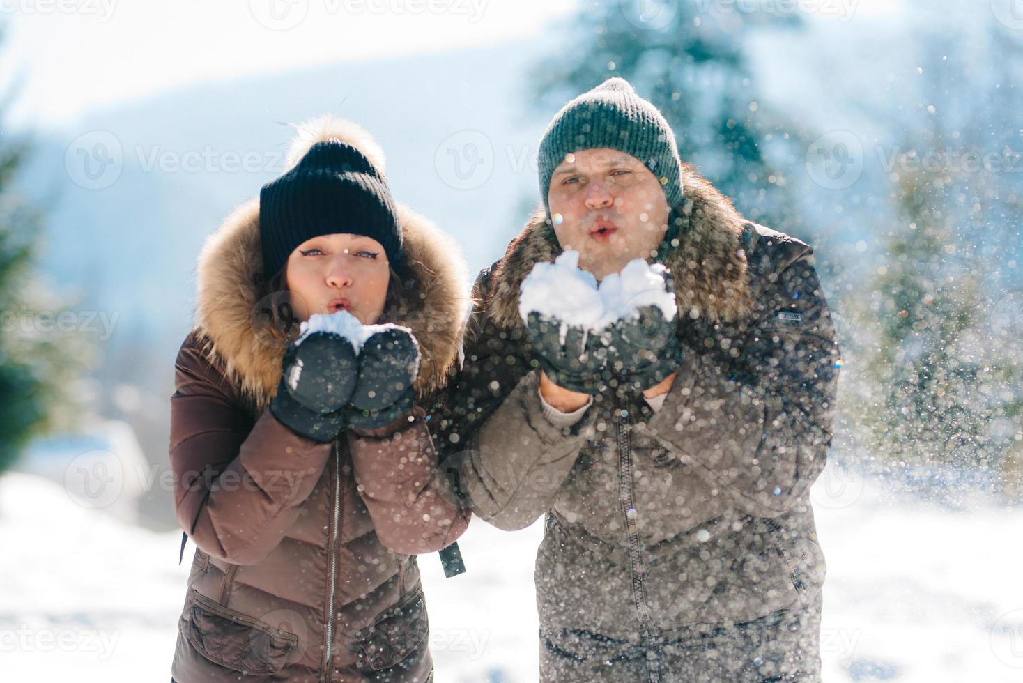 niño y niña al aire libre en un paseo de invierno jugando bolas de nieve foto