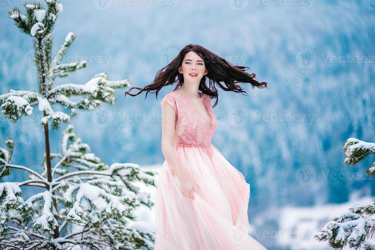 bride with chestnut hair blue background of the winter mountains photo