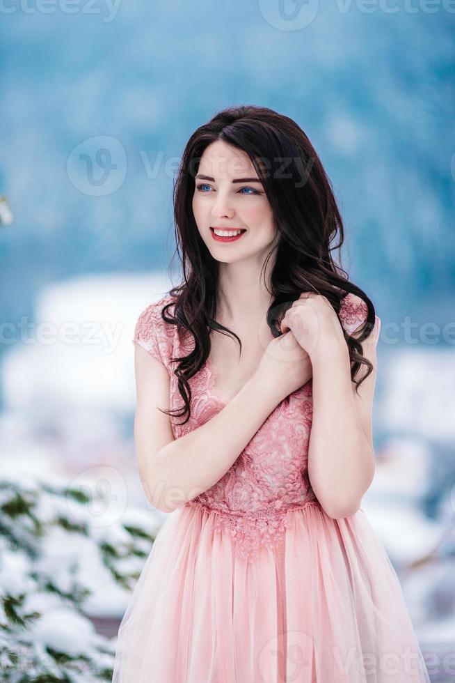 bride with chestnut hair blue background of the winter mountains photo