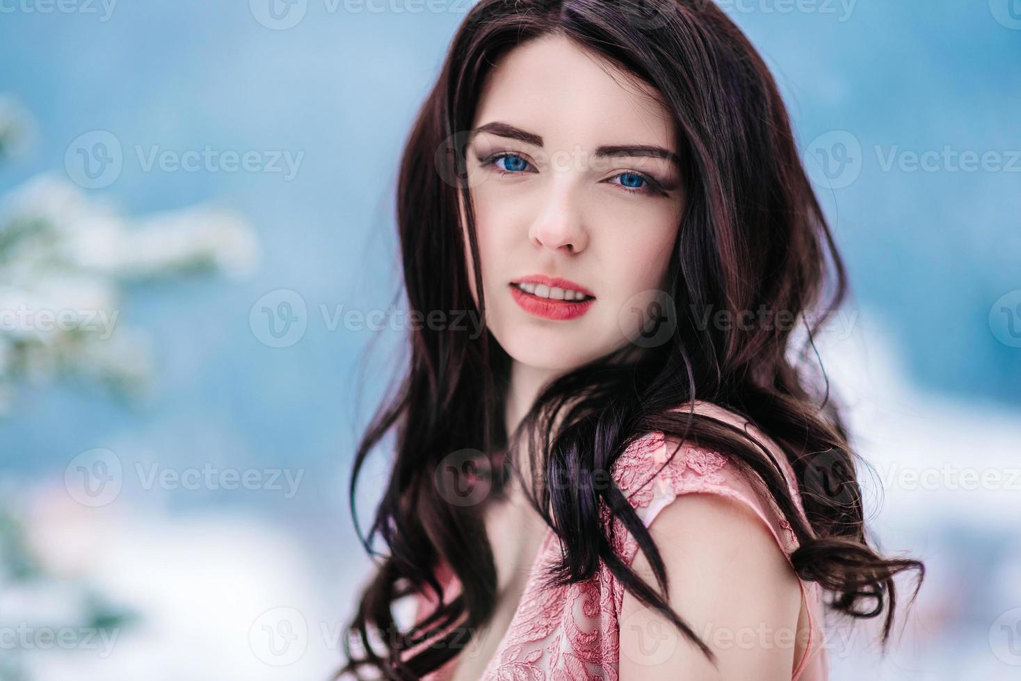 bride with chestnut hair blue background of the winter mountains photo