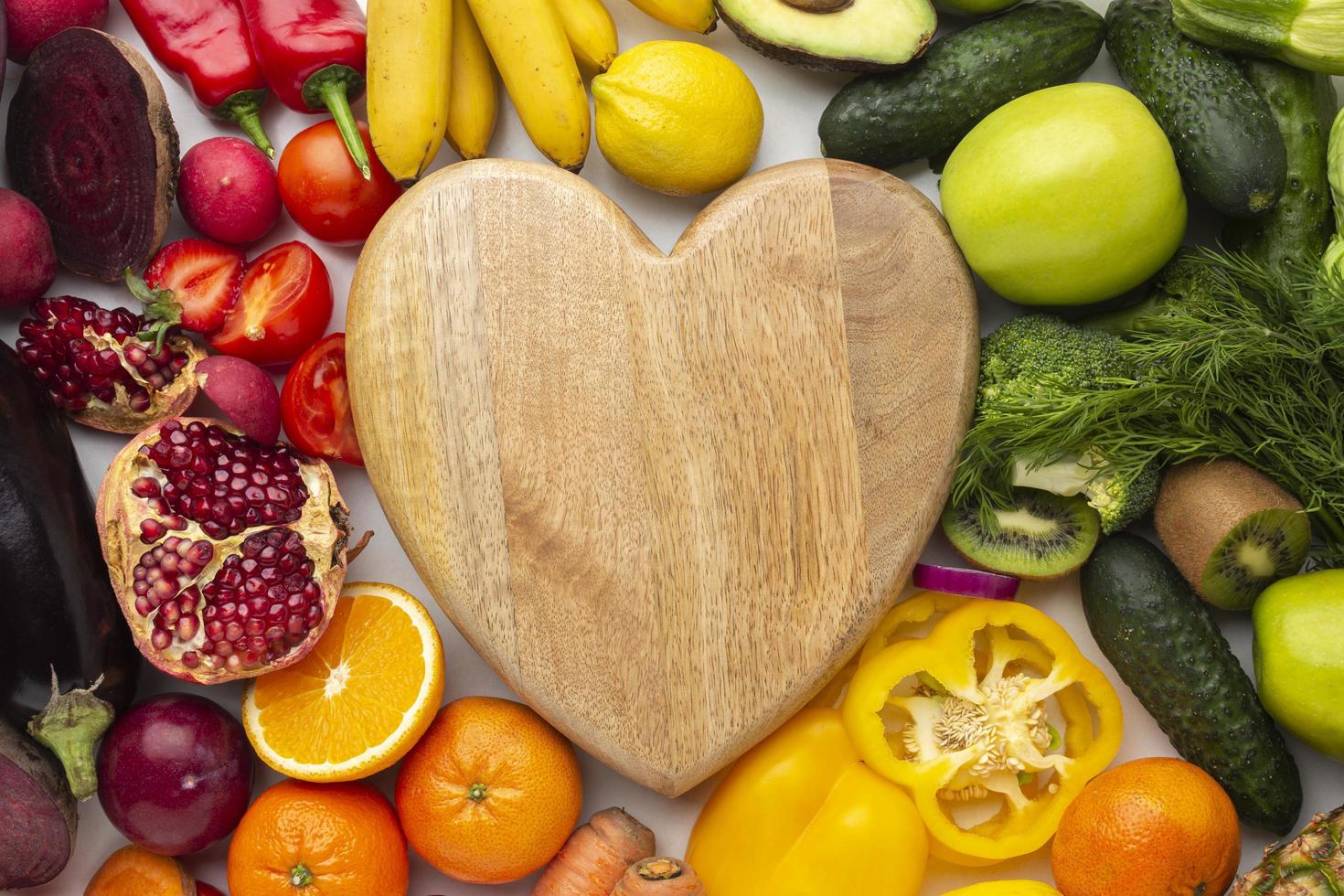 Heart-shaped board with fruit and vegetables photo