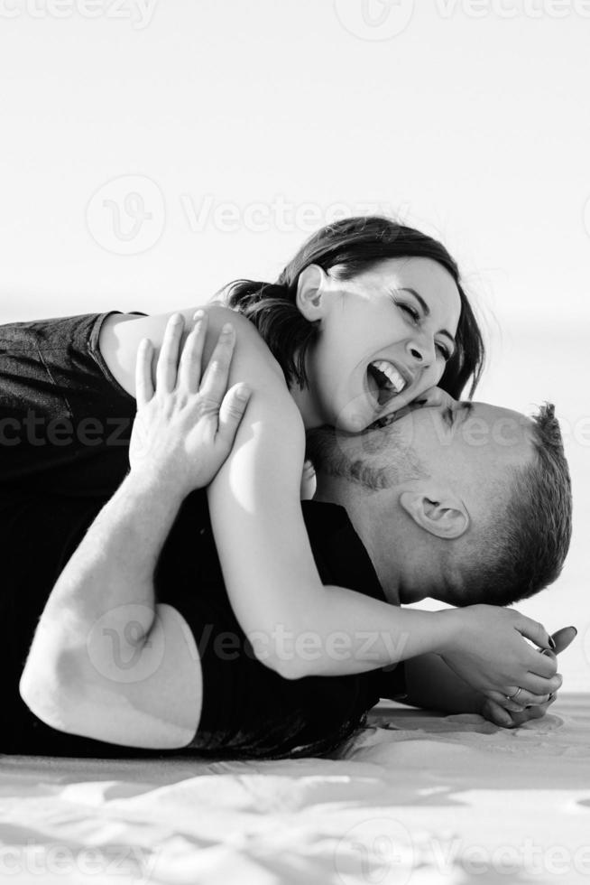 young couple a guy and a girl with joyful emotions in black clothes walk through the white desert photo