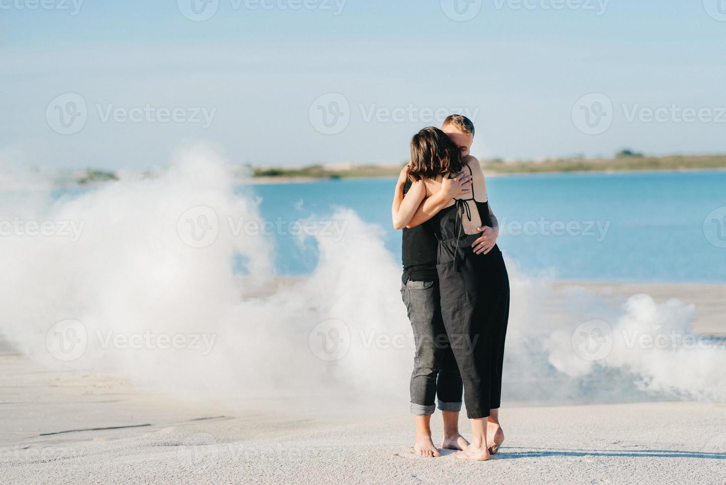 guy and a girl in black clothes hug inside a  smoke photo