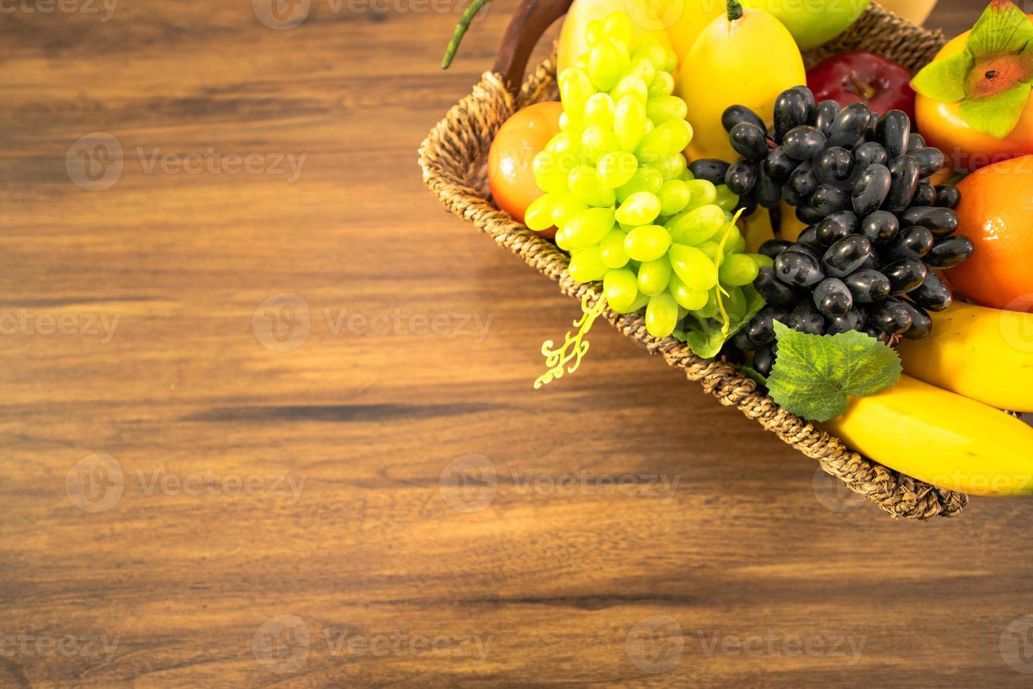 Verduras para hacer ensaladas y frutas en la canasta en la mesa foto