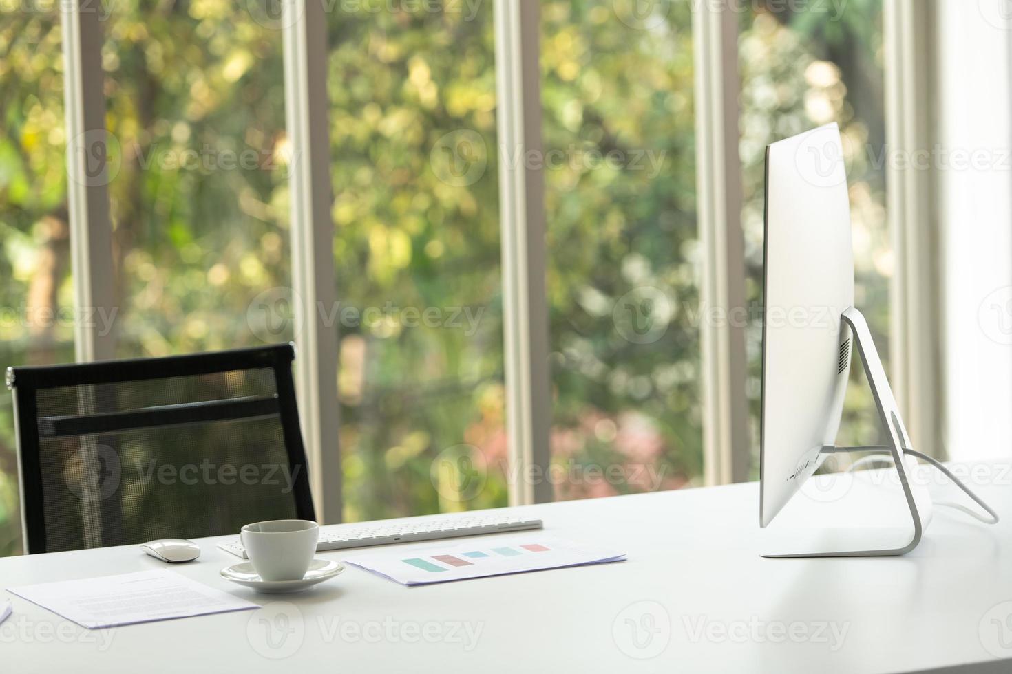 A large table with a computer of CEO and nature background photo