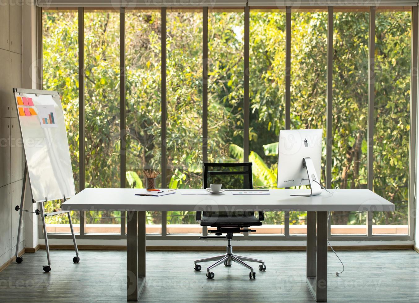 A large table with a computer of CEO and nature background photo