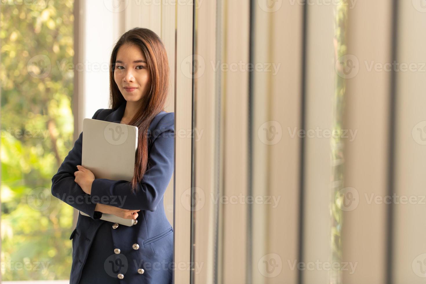 mujer de negocios asiática, tenencia, computadora portátil foto