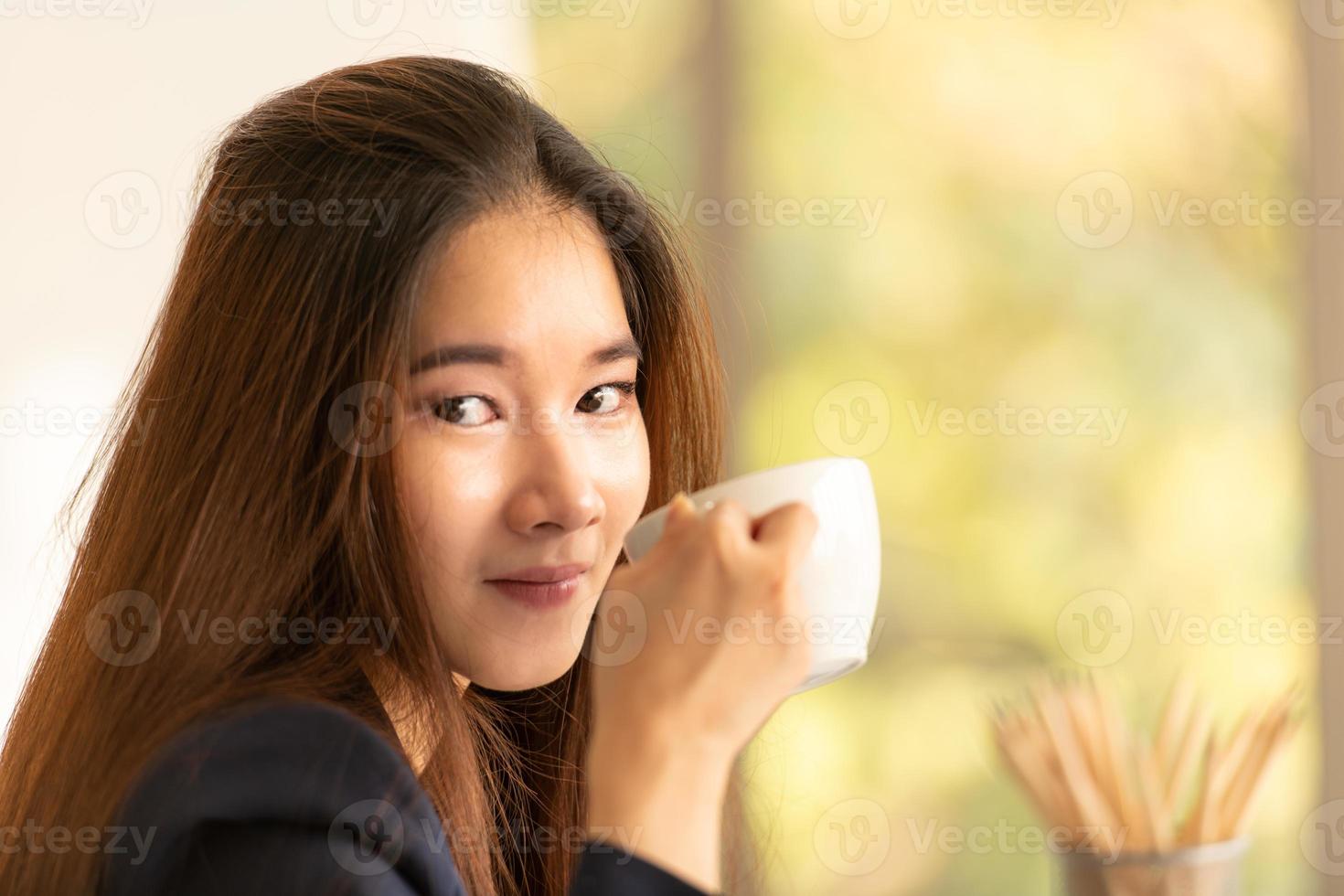 Mujer de negocios asiática tomando café en una oficina. foto