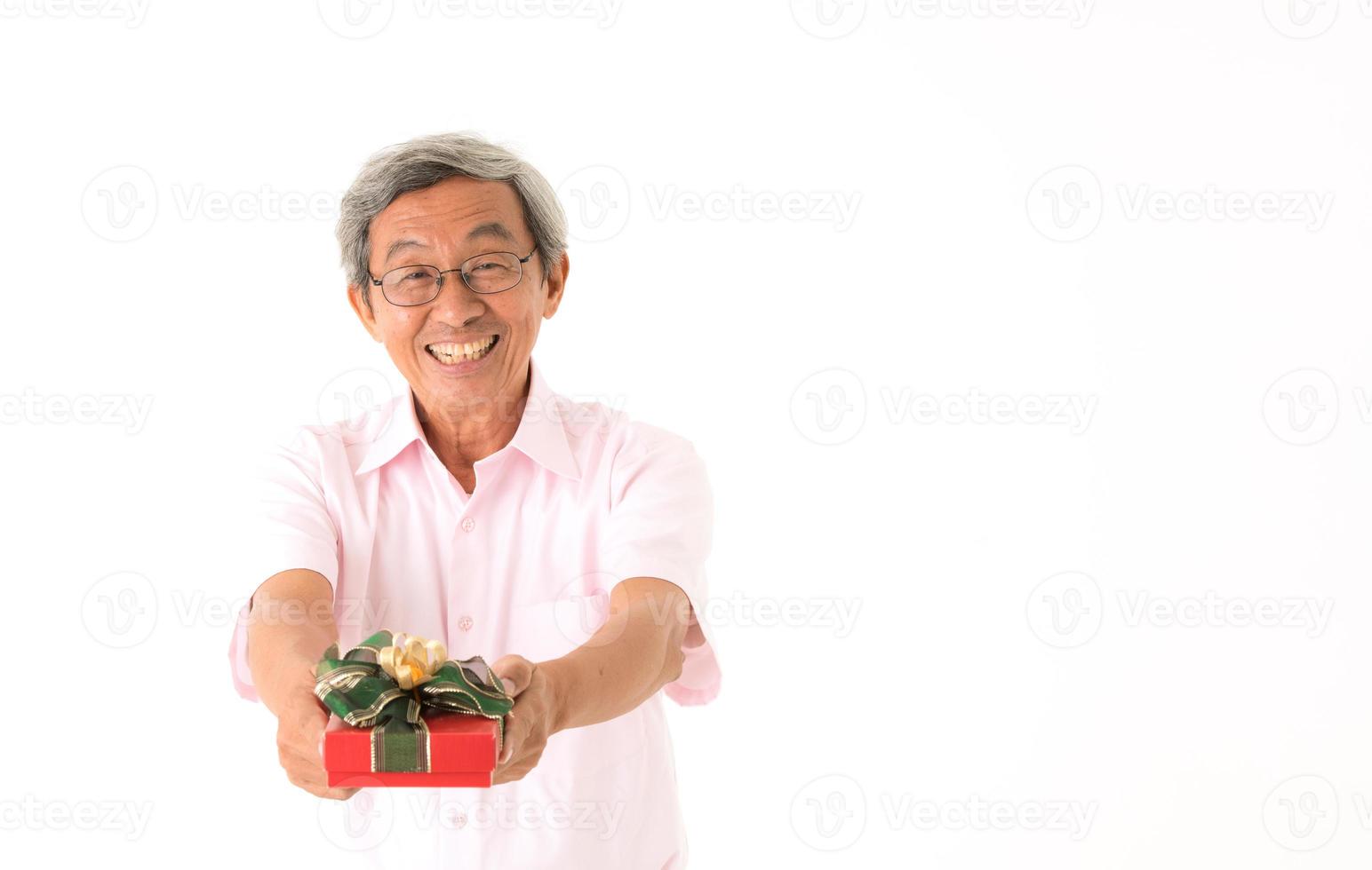 Senior hombre asiático con caja de regalo, aislado foto
