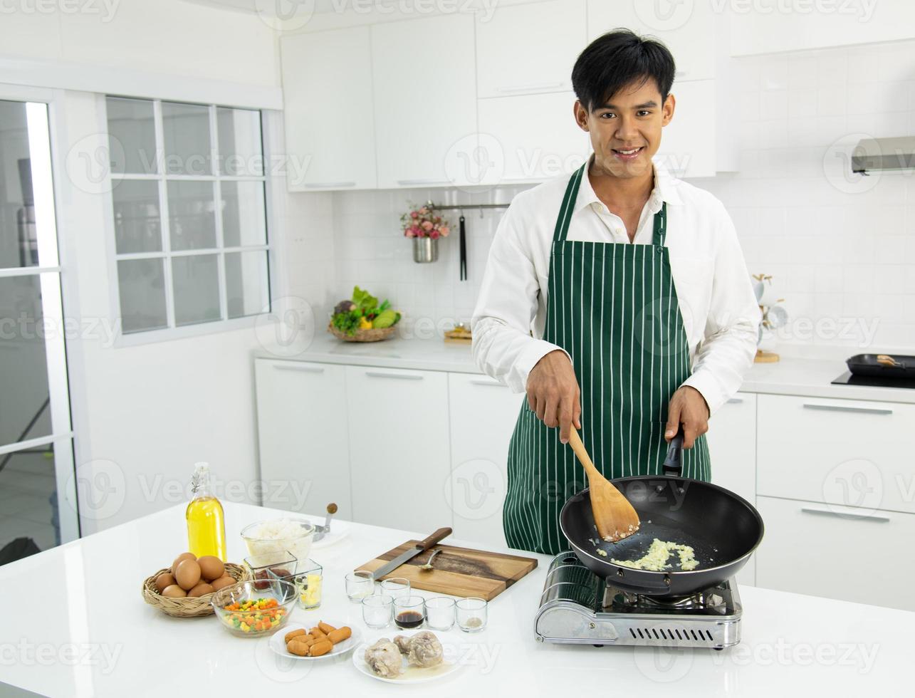 Asian male chef cooking fried rice in the kitchen photo