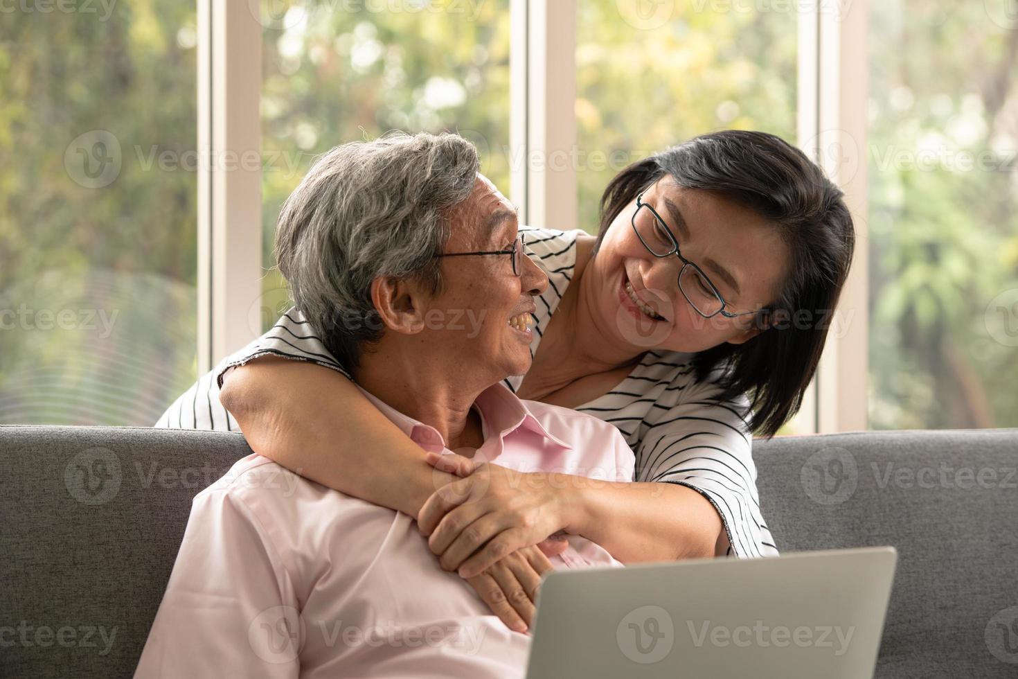 Senior Asian man and woman relax on holiday in the natural living room background with modern technology photo