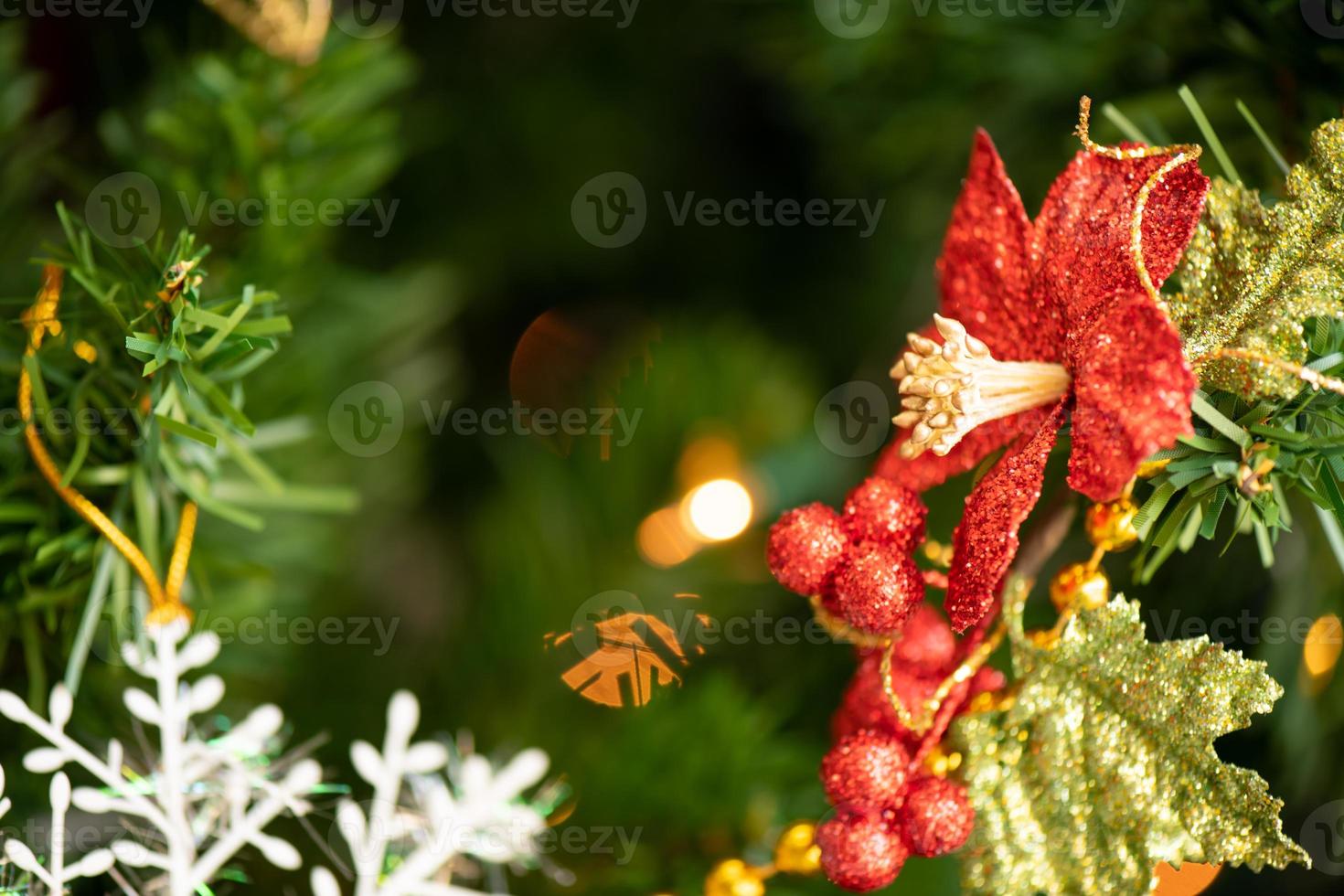 árbol de navidad decorado en la sala de estar para prepararse para el nuevo año. decora la sala y el árbol de navidad con una caja de bolas rojas, bolas doradas, campanas doradas, estrellas de nieve, calcetines. foto