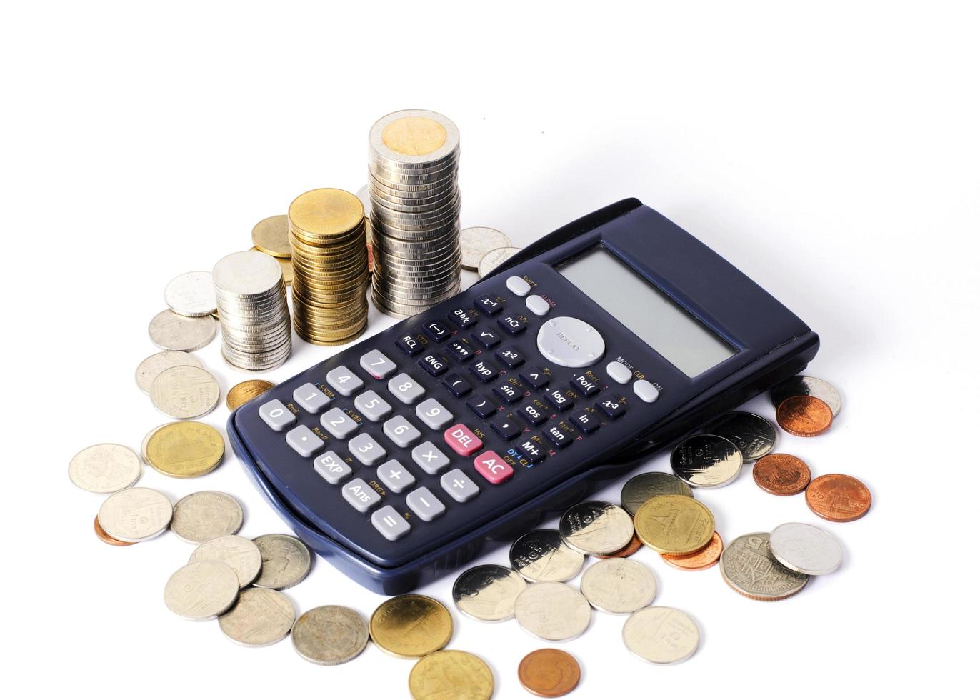 Calculadora y pila de monedas para el fondo del concepto de finanzas empresariales foto
