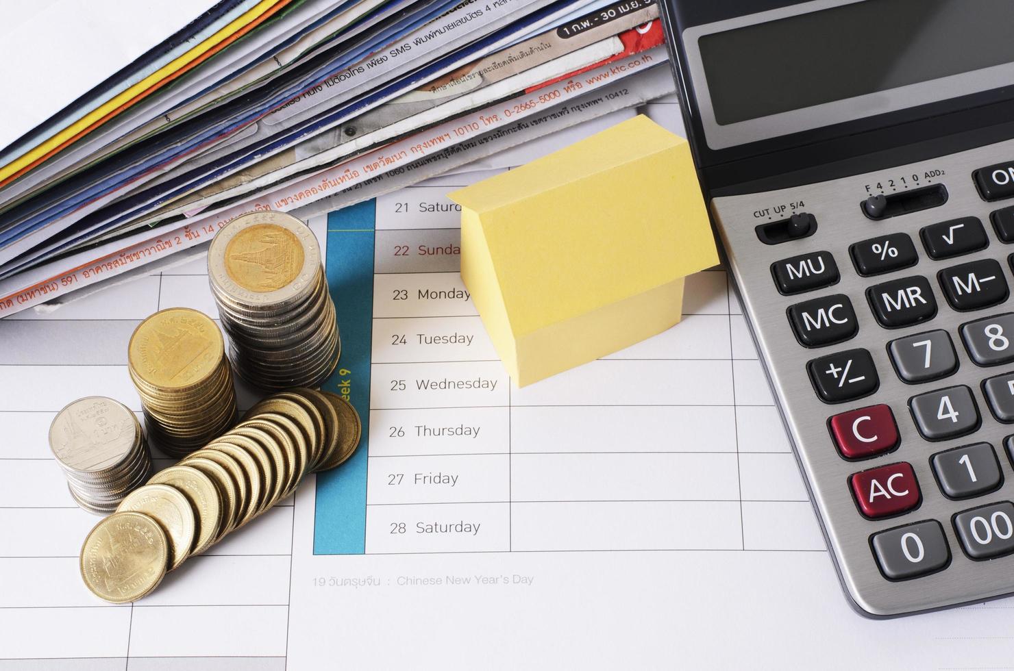 house and coin stack with calculator and bill payment for loan money concept photo