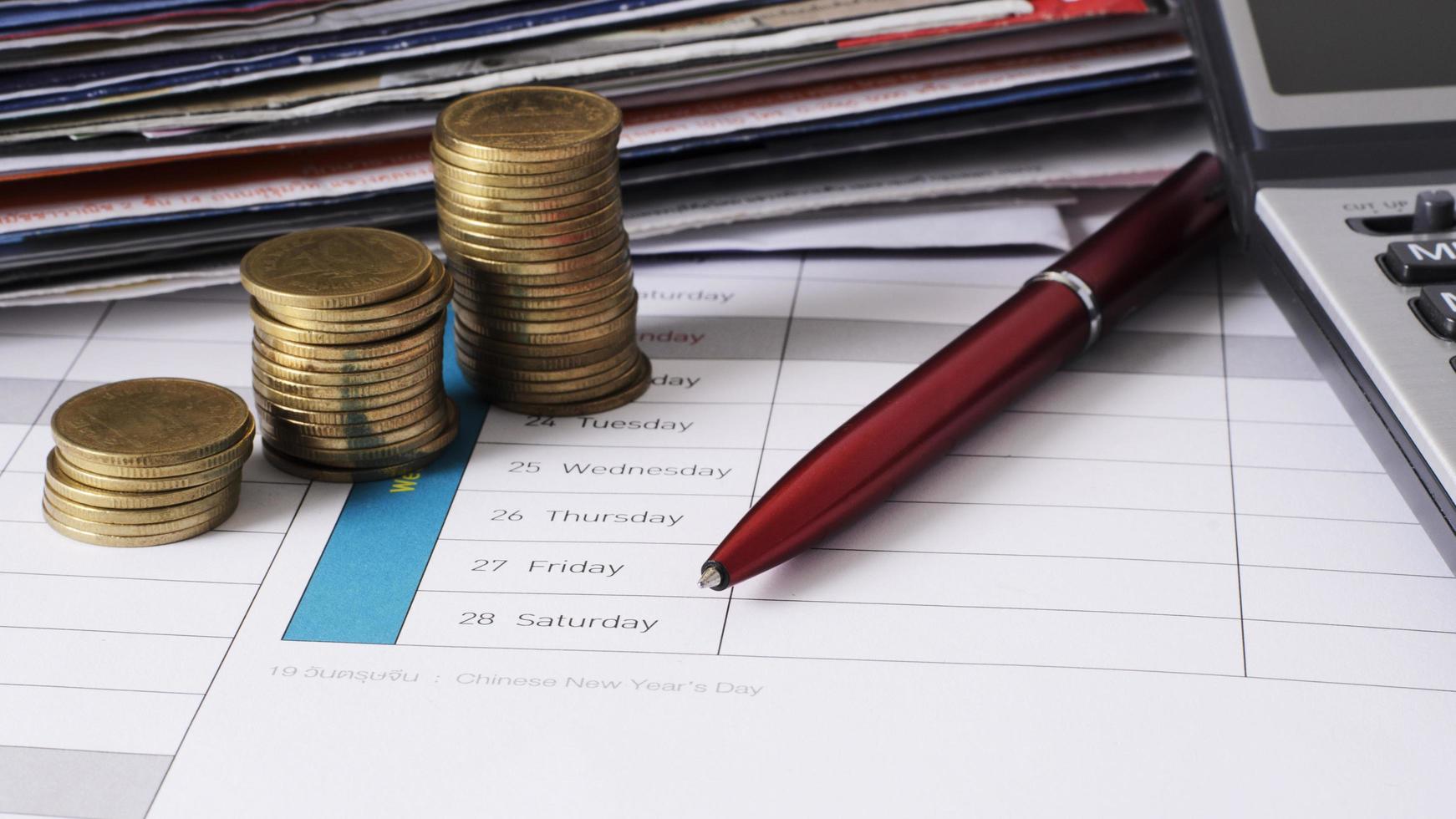 money coins stack and red pen for due date payment concept background photo