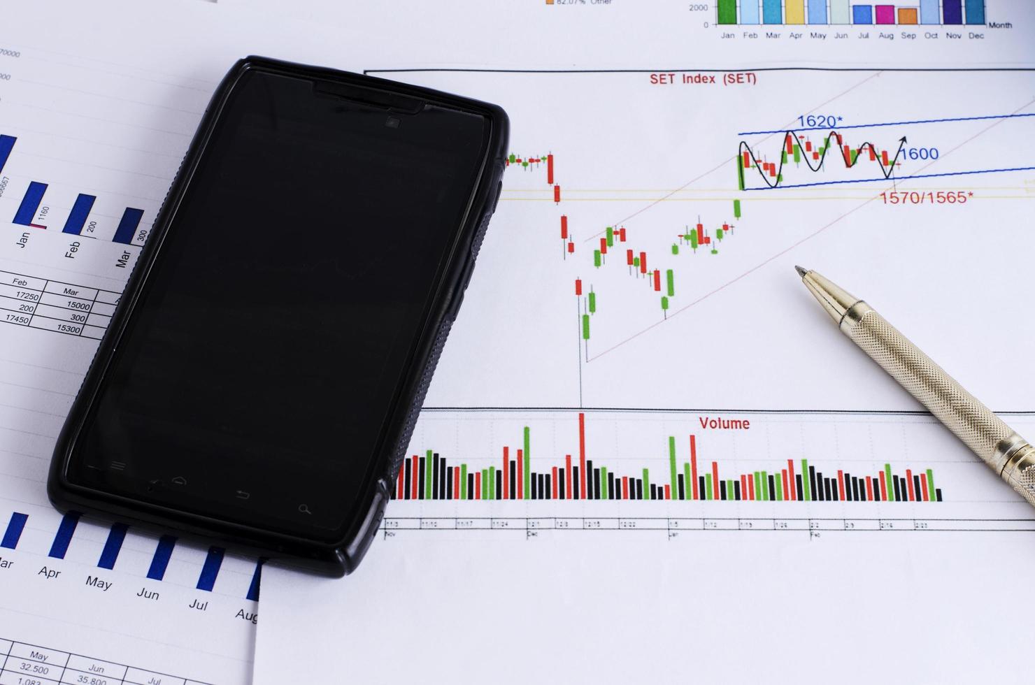 Finance concept with close up of smartphone and pen photo
