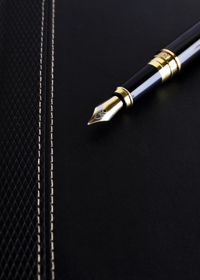 Close up of Fountain pen on leather cover book for Business concept photo