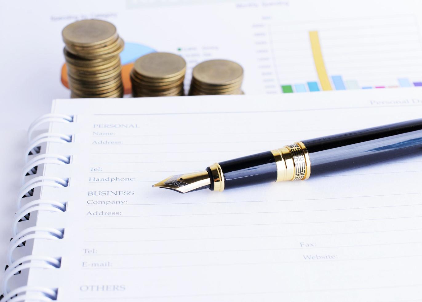 Business Fountain pen and Coins stack on document report photo