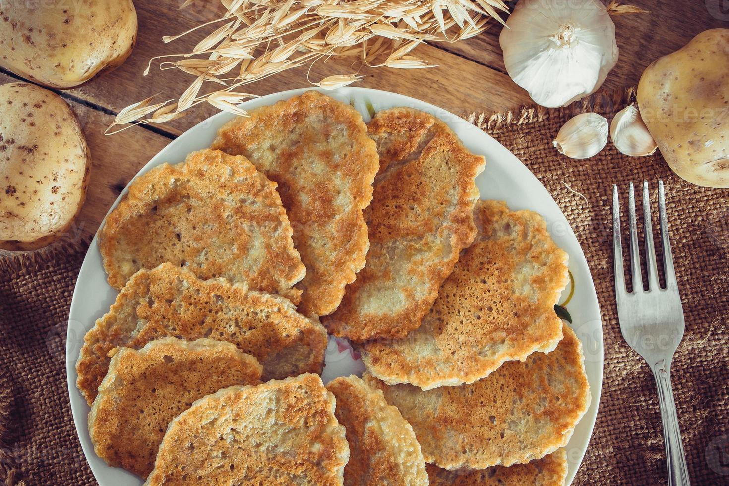 Tortitas de patata en un plato y tenedor sobre fondo de lino foto