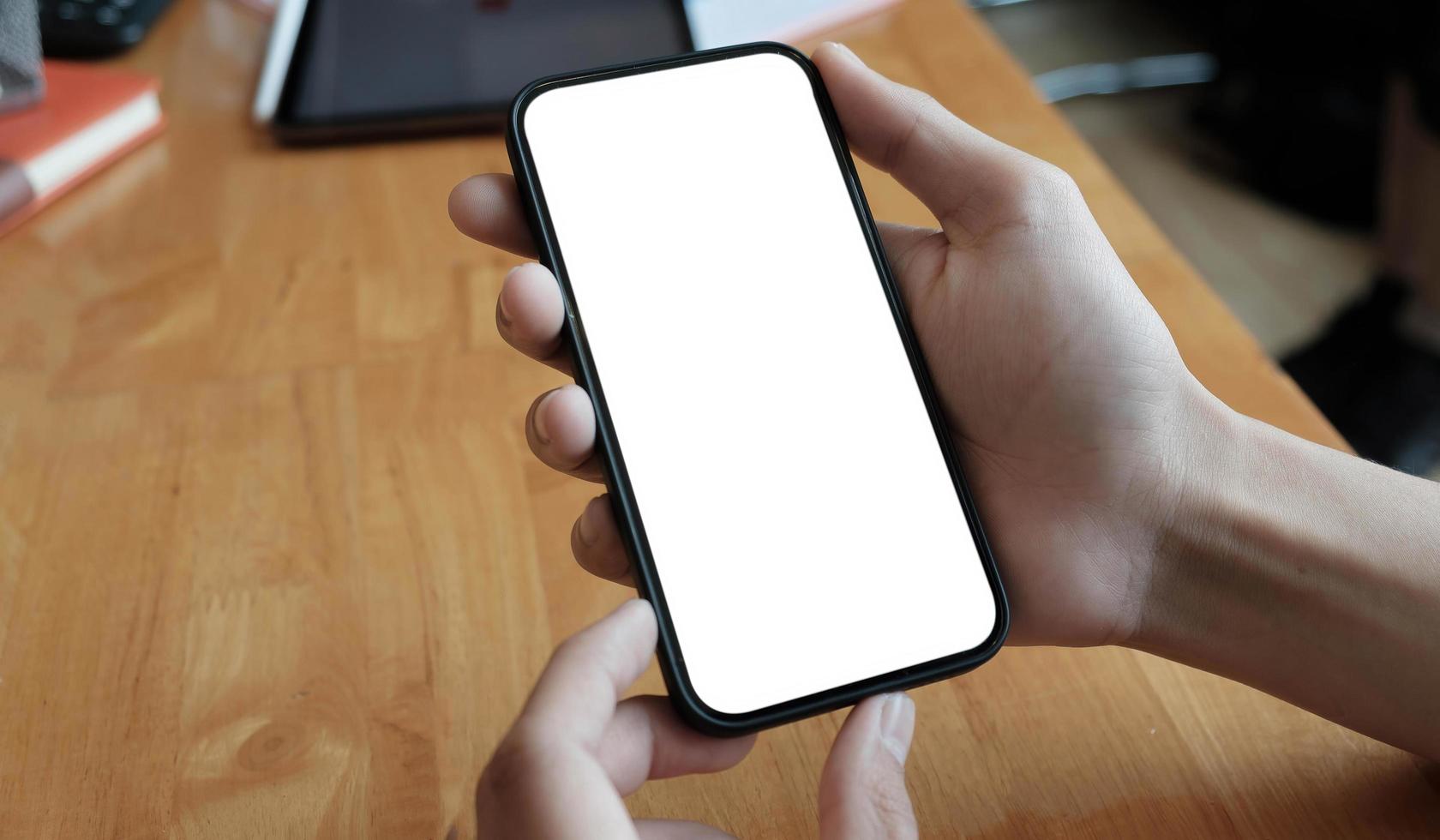 Vista recortada de una mujer joven que sostiene un teléfono inteligente con un área de pantalla en blanco para su internet. foto