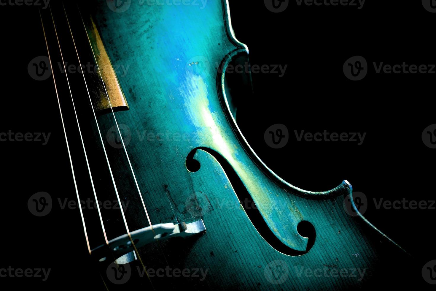 A cello in aqua blue on black background photo