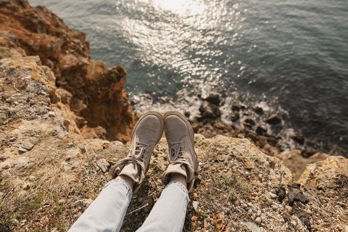 Woman's feet lying next to a cliff near the sea photo