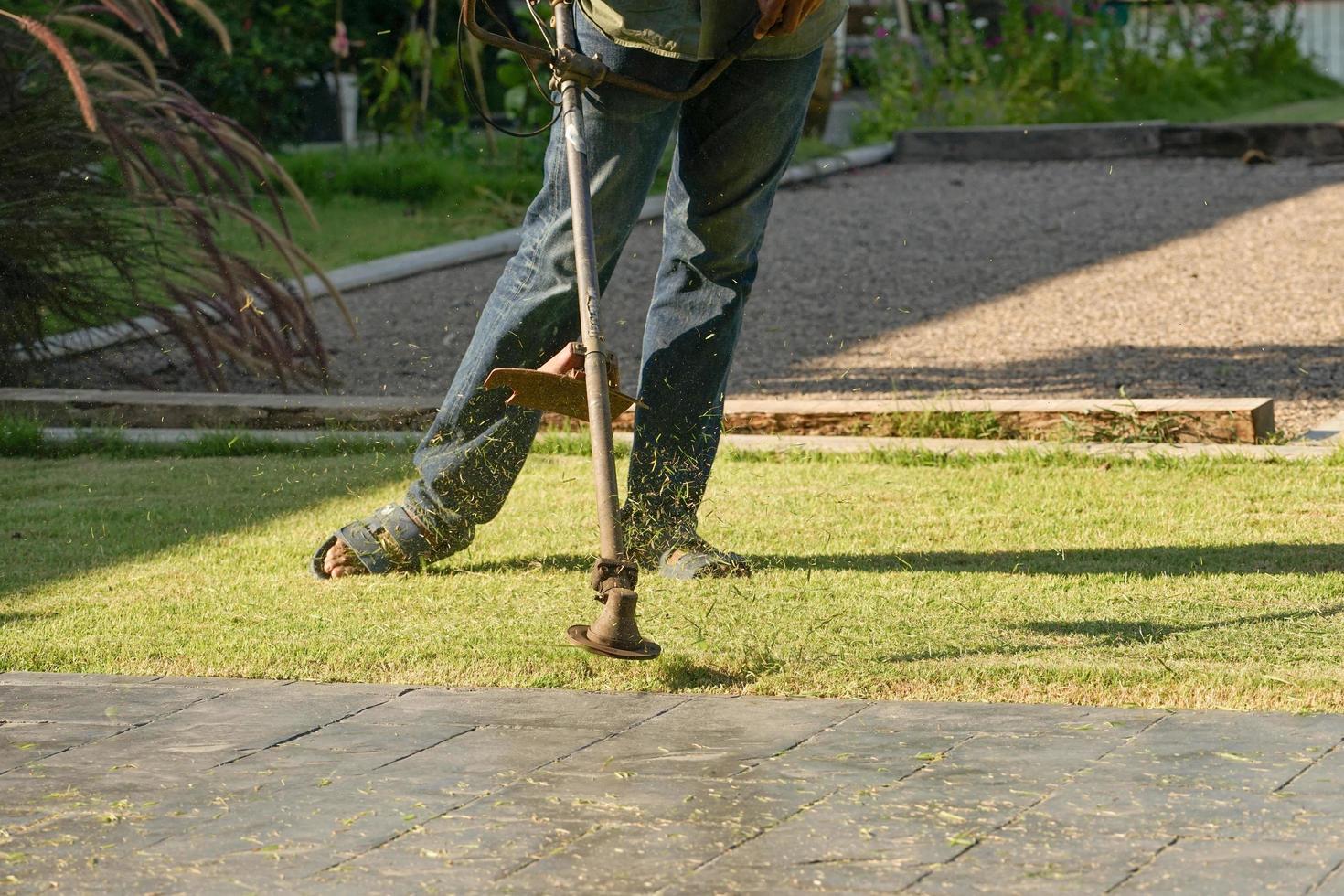 Gardener mowing the grass field photo