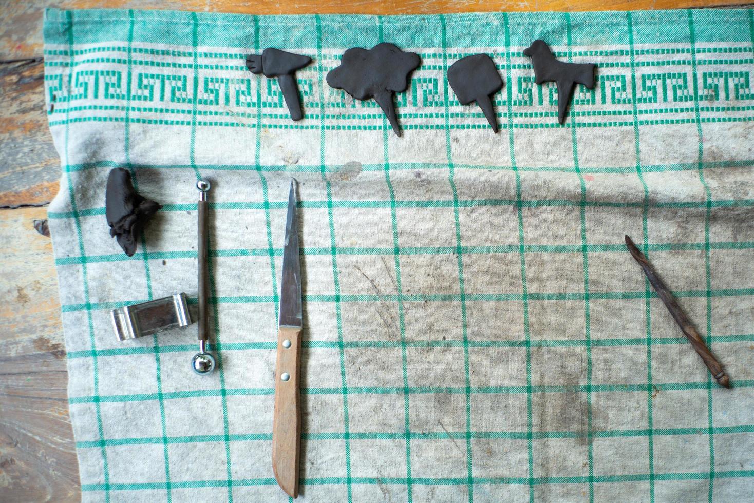 Tools on a dirty piece of cloth with artwork from molding clay in a workshop class with copy space for adding text photo
