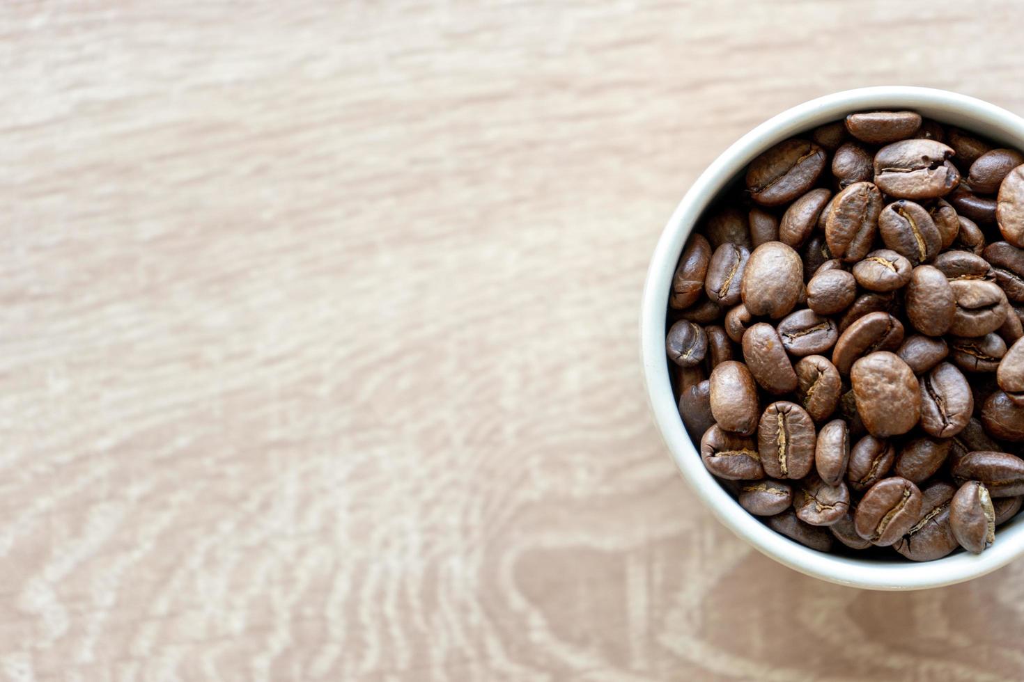 Acercamiento de muchos granos de café en una taza de cerámica con espacio de copia para agregar texto foto