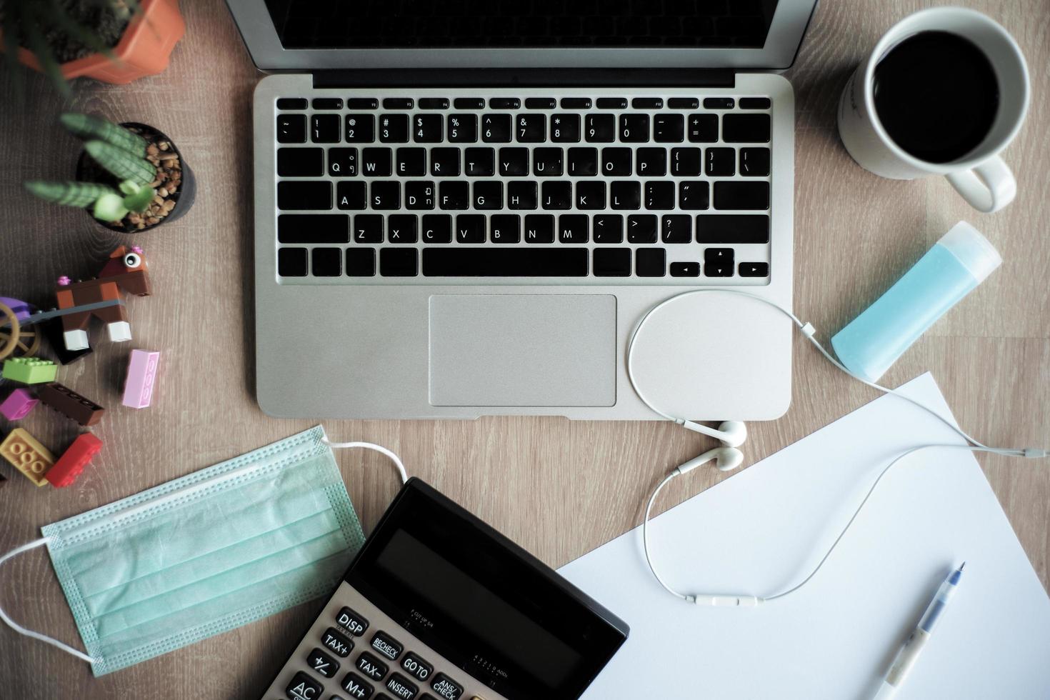 Top view of laptop on the wooden desk with stationary and a cup of coffee. Work from home. Quarantine at home photo