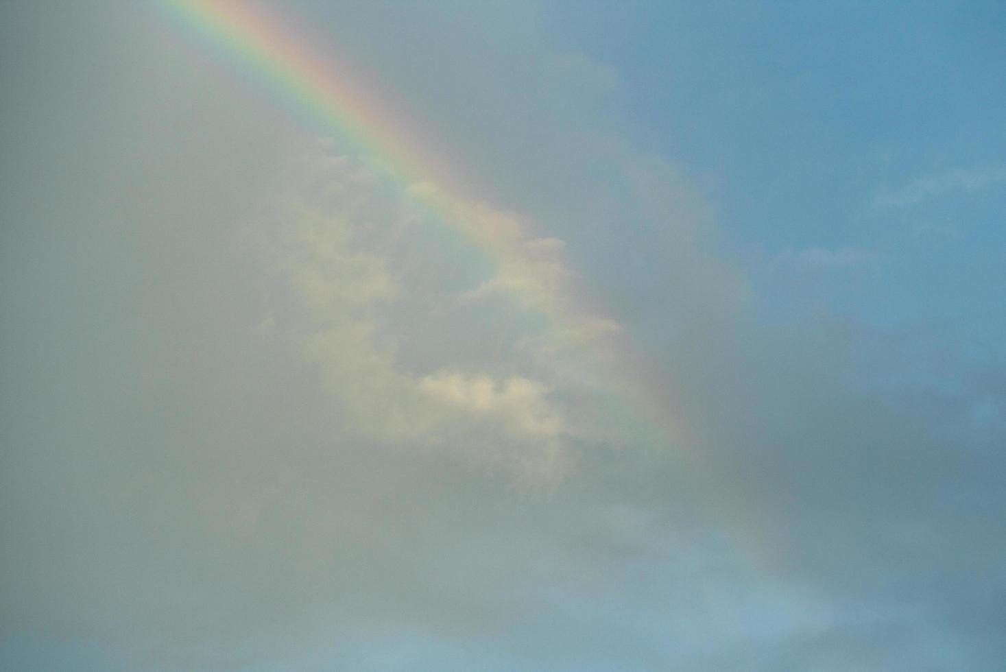 arco iris sobre un fondo de cielo azul nublado foto