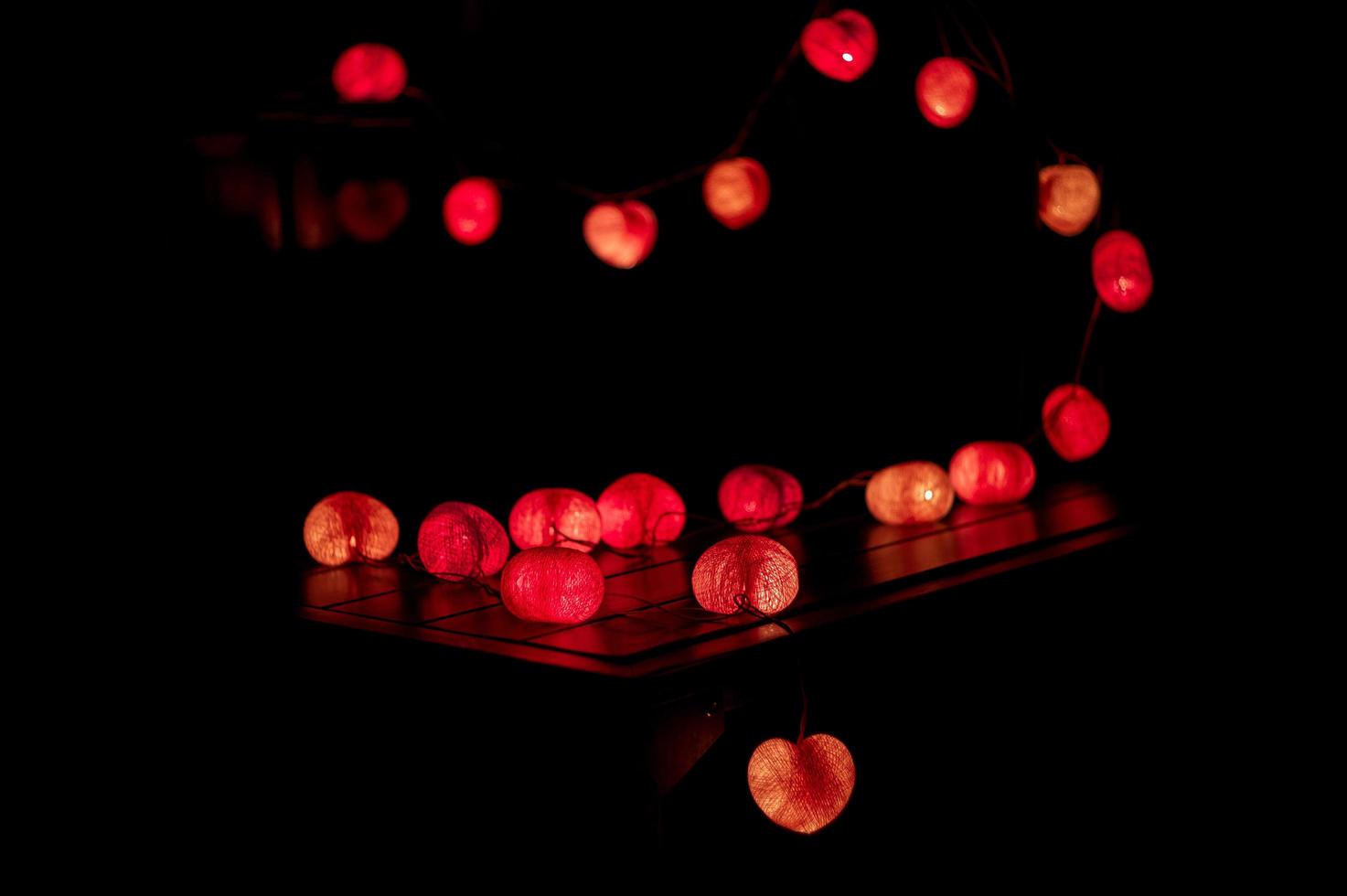 Primer plano de luces LED en forma de corazón decoradas en el cuarto oscuro foto