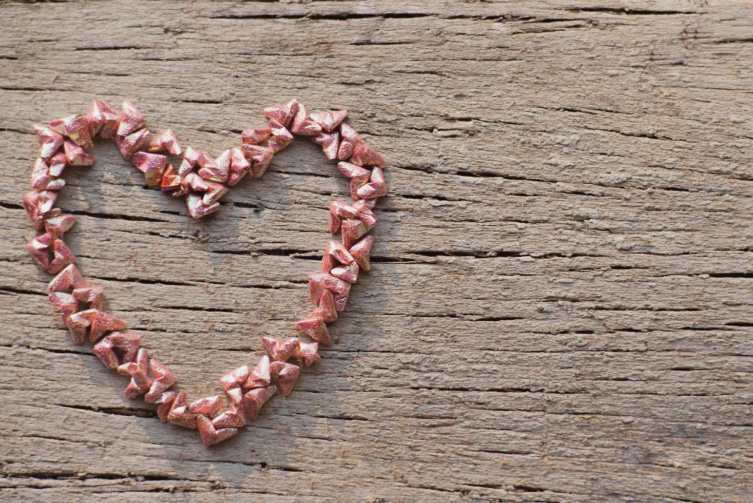 Top view of folding paper in little heart shape put on the wooden surface photo