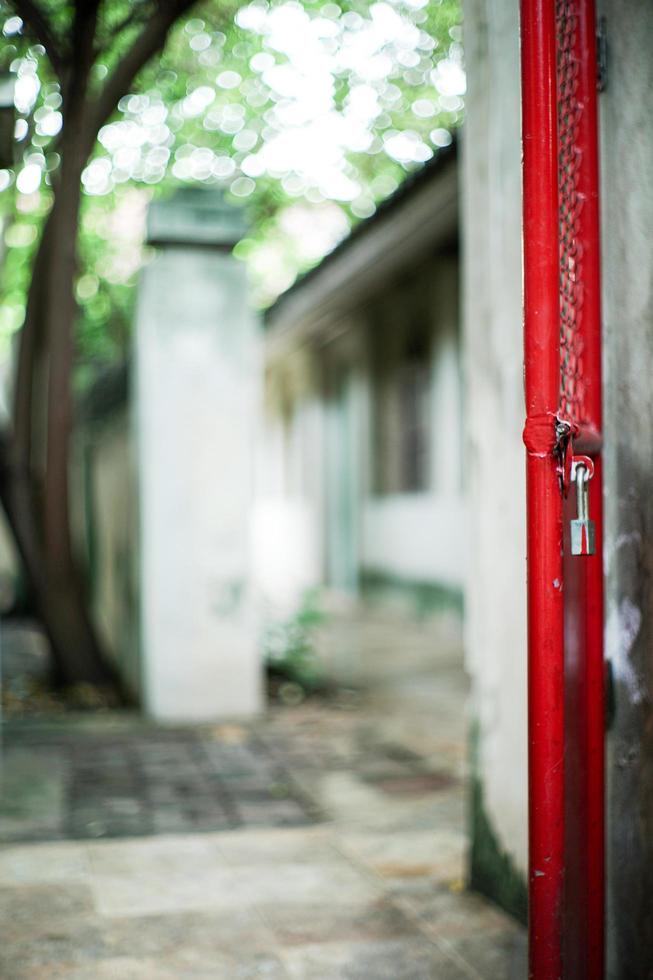 Selective focus on red steel frame of door with blurred glittering bokeh light and tree in background photo