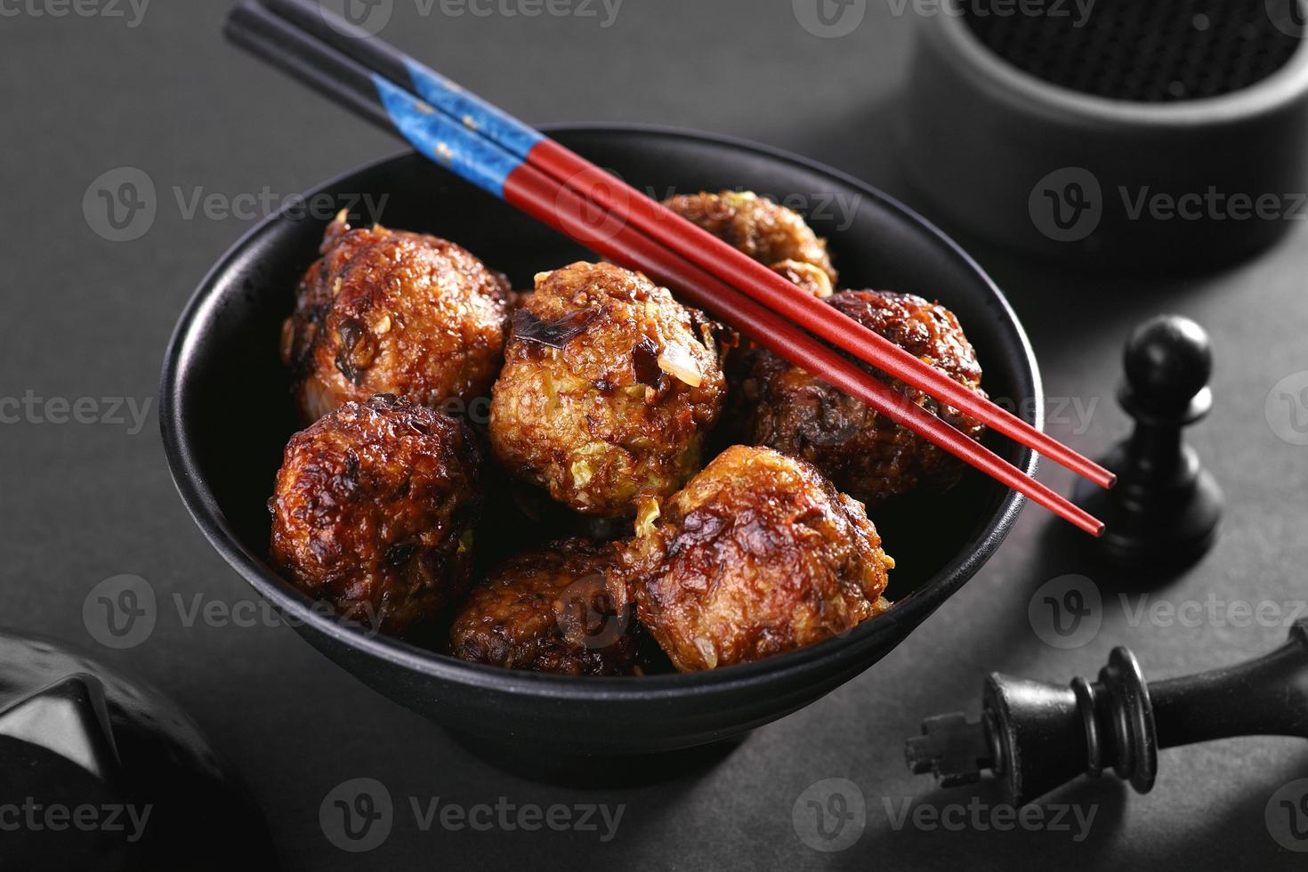 Chinese manchurian in a bowl with chopsticks photo