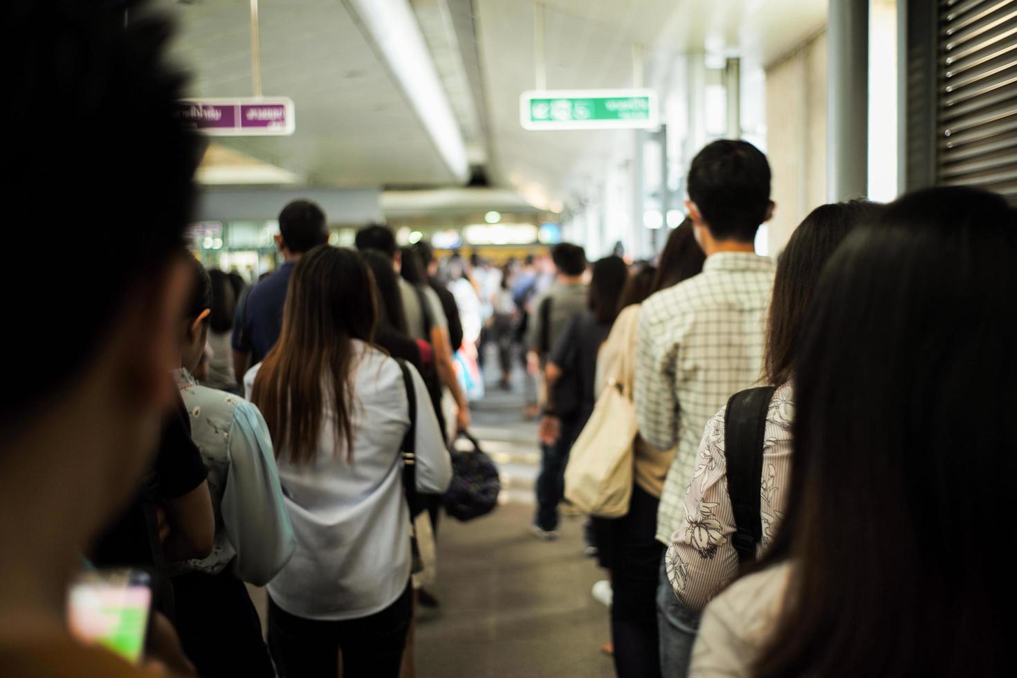 Retrato de espalda multitud de personas esperando el tren en el andén de la estación foto