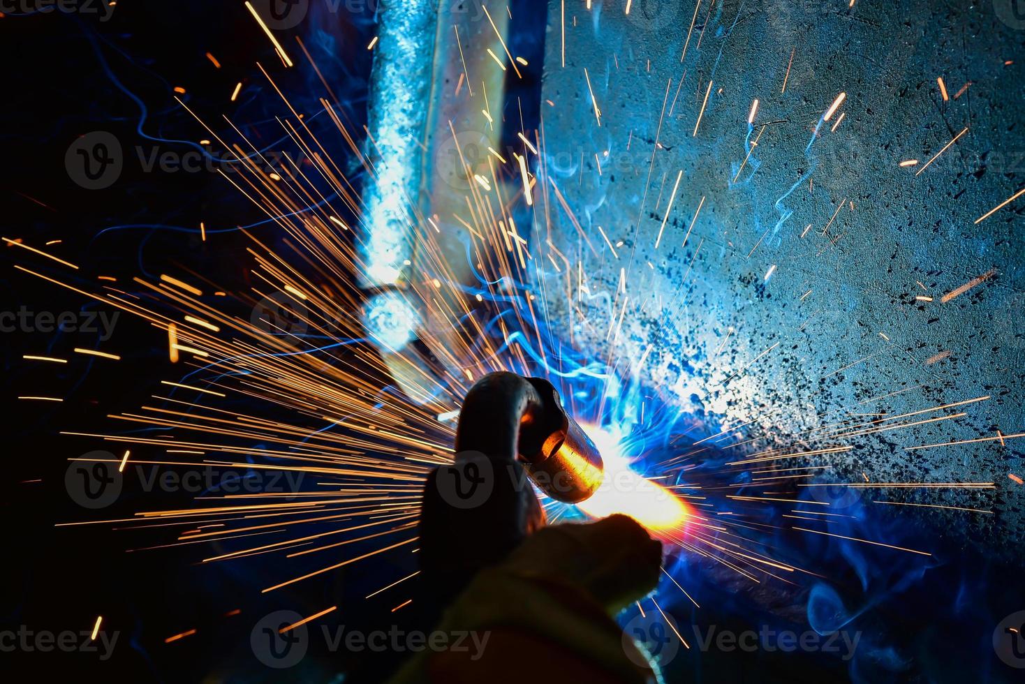 Welder, or craftsman, erecting technical industrial steel in factory photo