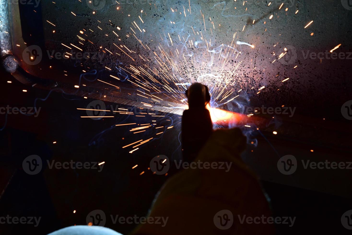 Welder, or craftsman, erecting technical industrial steel in factory photo