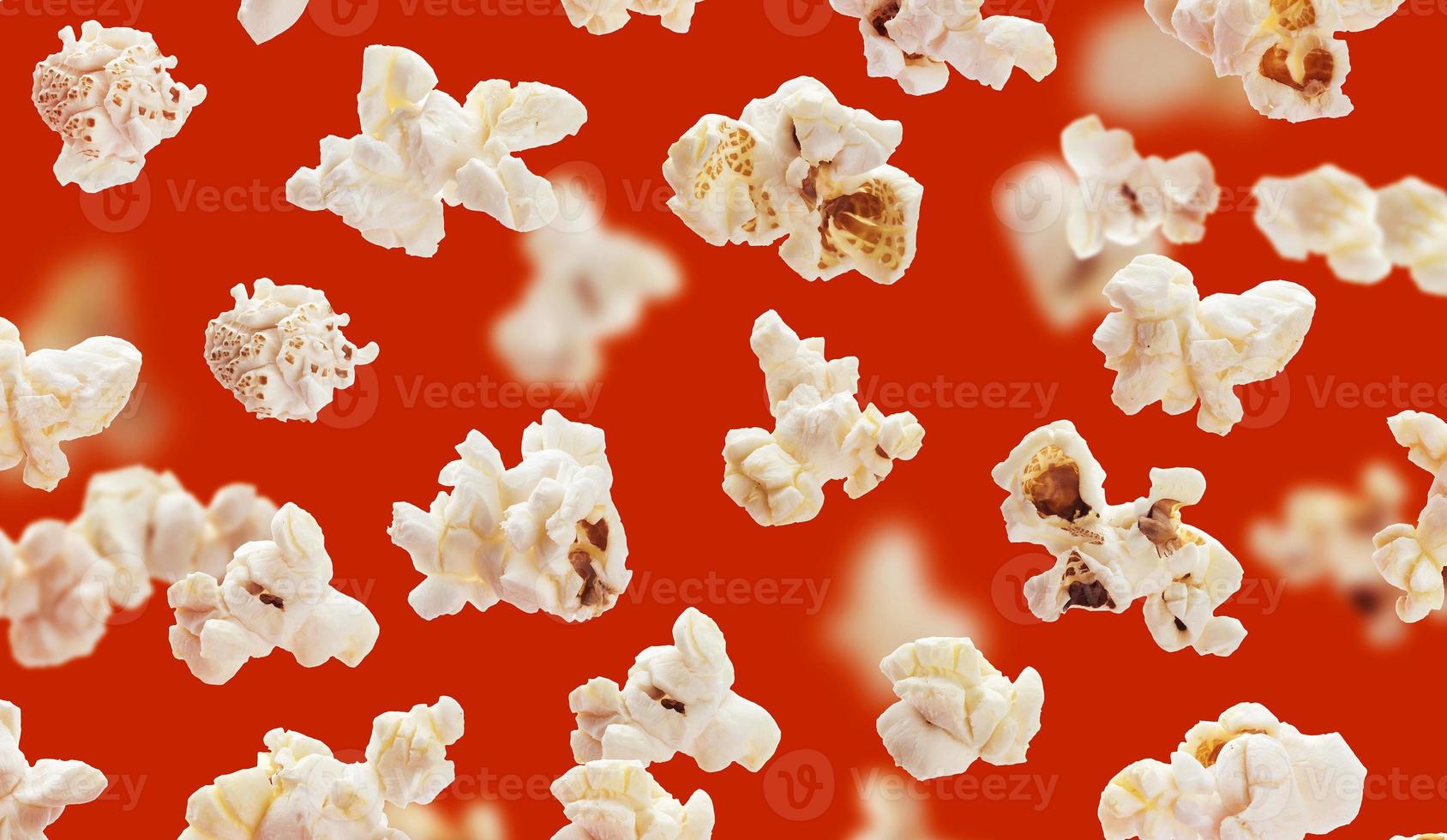 Delicious popcorn grains closeup on red background photo