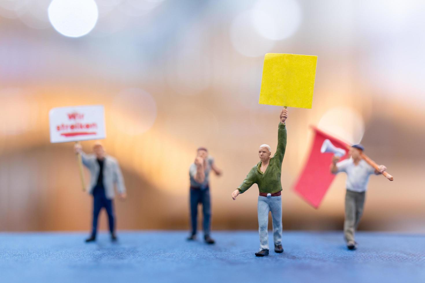 Miniature people, protesters holding signs, raising their hands for revolution photo