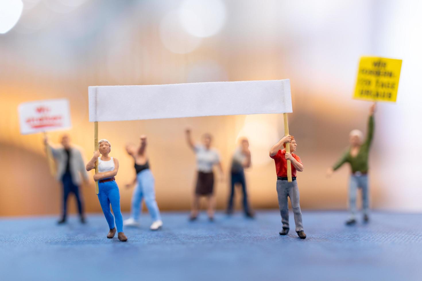 Miniature people, protesters holding signs, raising their hands for revolution photo