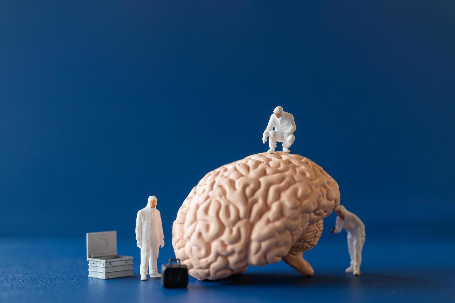 Miniature people, scientists observing and discussing the human brain, medical healthcare and surgical doctor service concept. photo