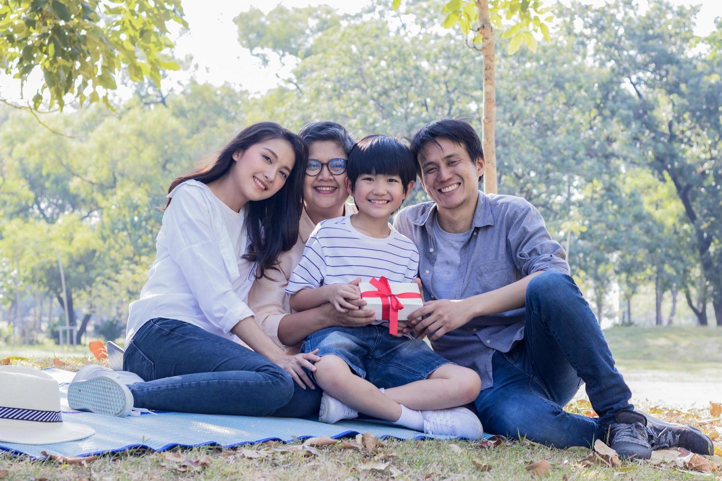 familia asiática disfruta de sentarse en el parque en las vacaciones de otoño. foto