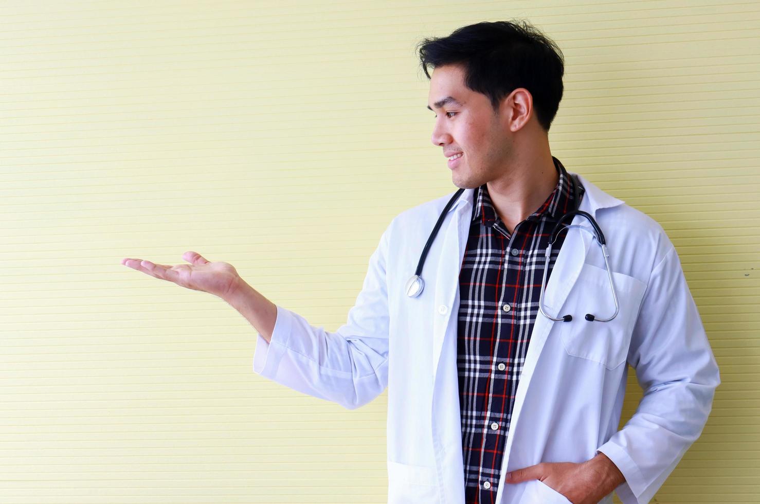 Portrait young doctor on yellow background photo