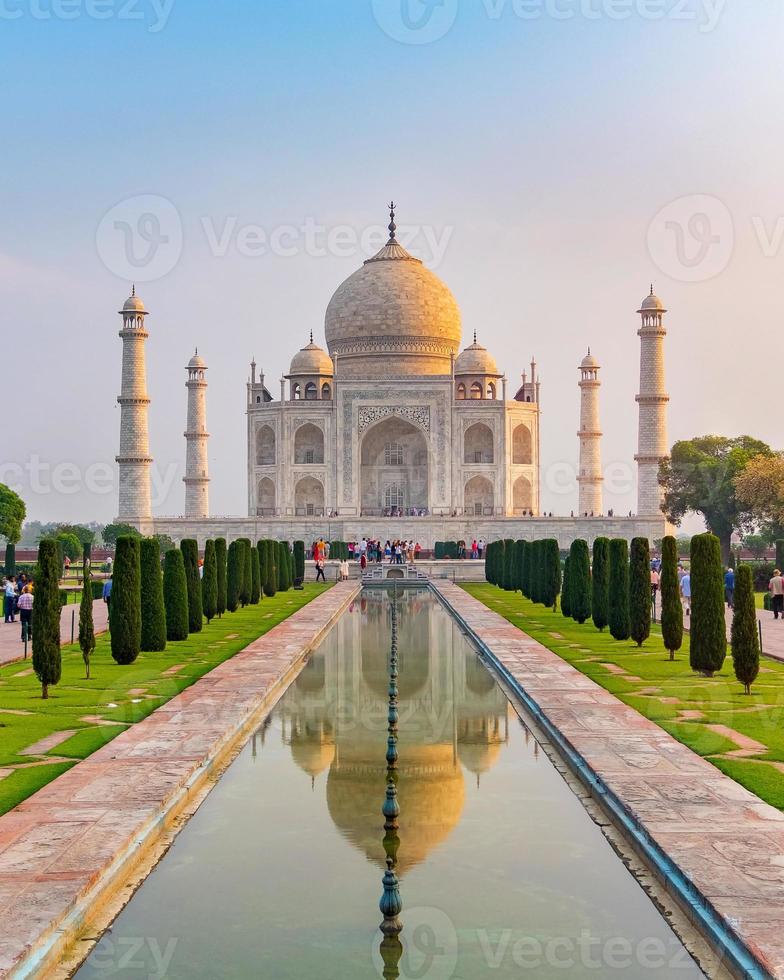 Vista frontal del taj mahal reflejada en la piscina de reflexión, un mausoleo de mármol blanco marfil en la orilla sur del río yamuna en agra, uttar pradesh, india. una de las siete maravillas del mundo. foto